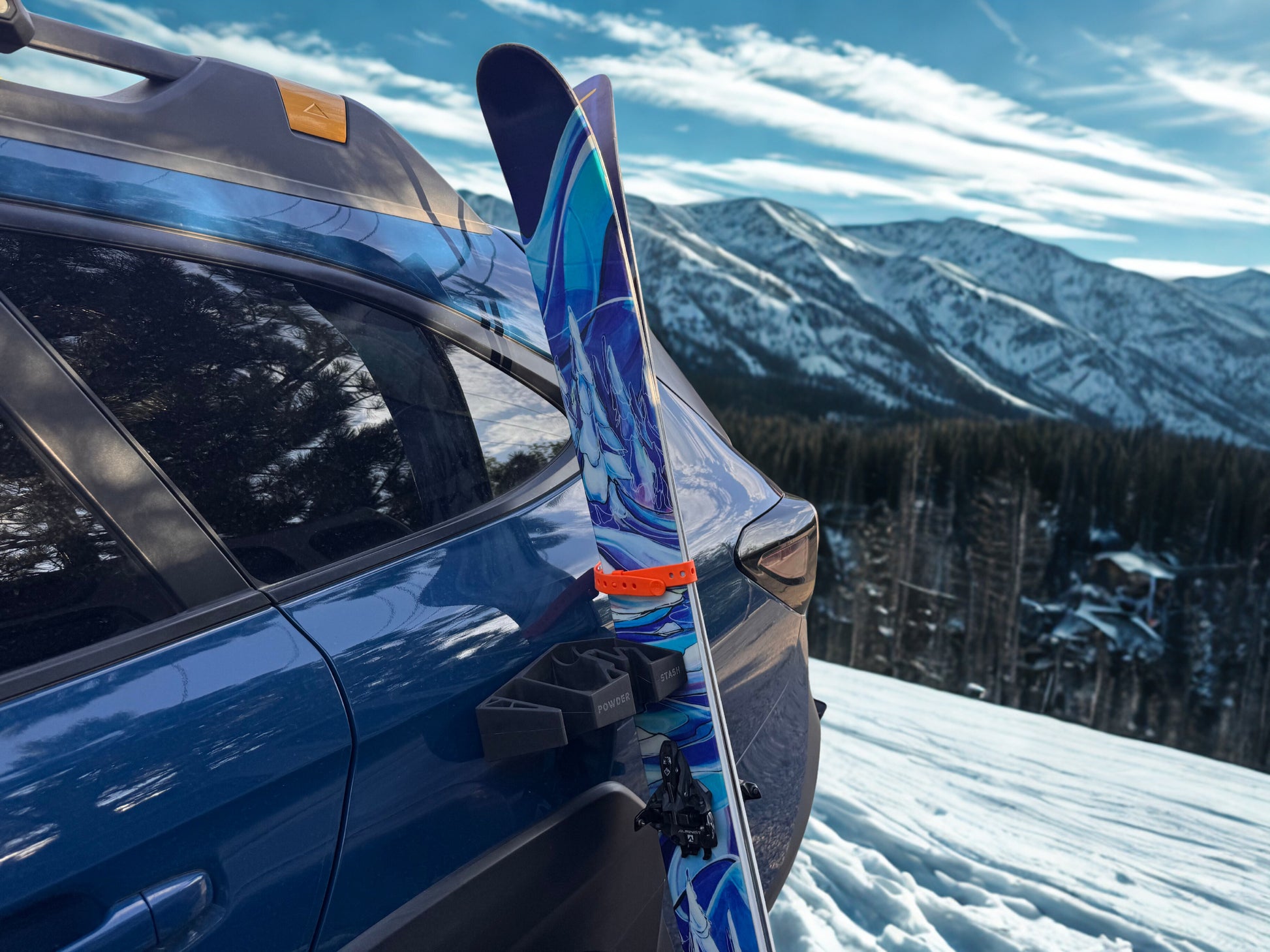 Powder Stash holder gripping skis on a steel vehicle panel